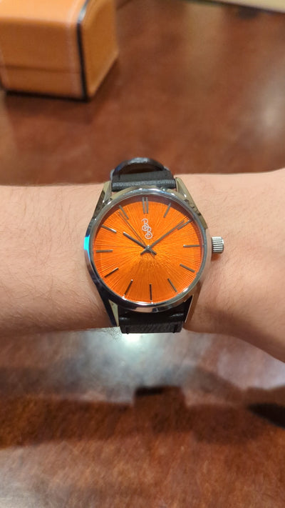 Orangefarbene Sunburst-Uhr
